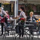 woman cleaning an outdoor restaurant table